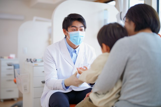 歯科医師に説明を受ける親子